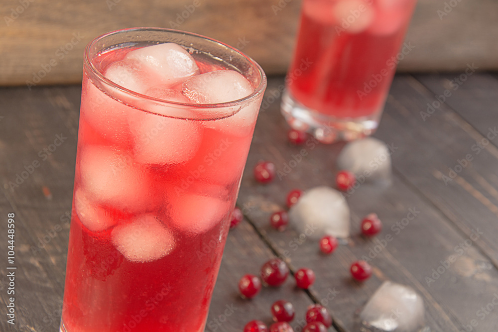 Glass of red currants juice, ice cubes and fresh berries on a wooden table.Closeup.Berry juice Glass of red currants juice, ice cubes and fresh berries on a wooden table.Closeup.Berry juice
