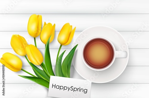 Cup of coffee with yellow tulips and paper on a white wooden background