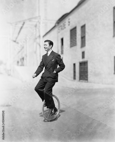 Profile of a young man riding a unicycle 