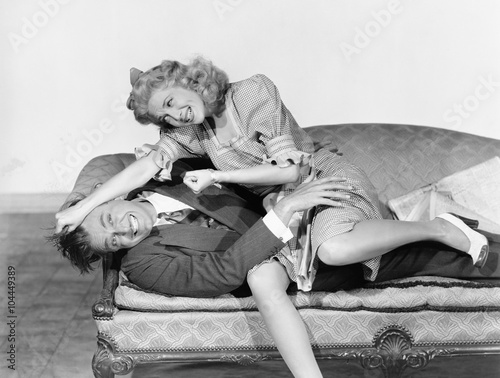 Couple having a playful fight on a couch  photo