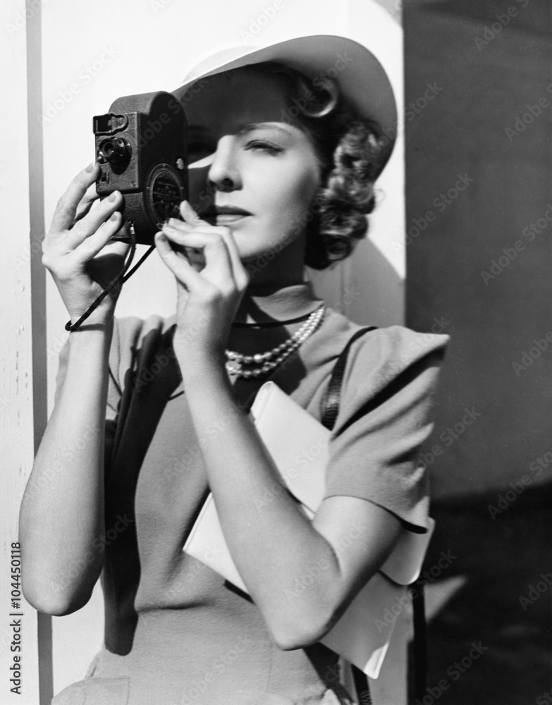 Portrait of a young woman taking a picture with a camera Portrait of a young woman taking a picture with a camera