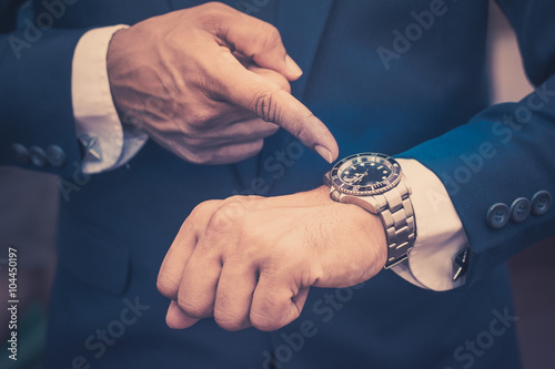 Businessman checking his watch vintage background
