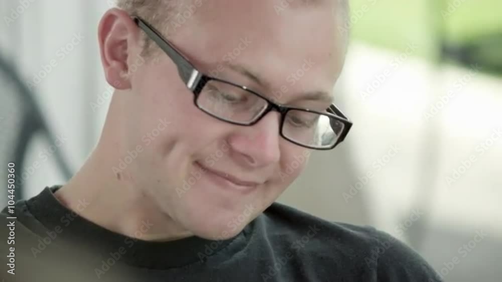 Tight shot of a teenage boy with glasses talking and smiling. Tight shot of a teenage boy with glasses talking and smiling.