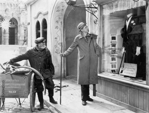 Man looking at a window display of a tuxedo 