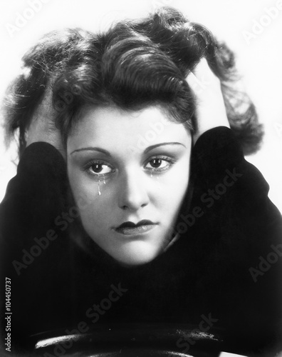 Young woman crying and holding her head in her hands  photo