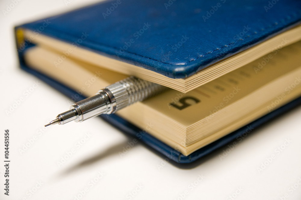 Blue diary and mechanical pencil within (focus at pencil) Blue diary and mechanical pencil within (focus at pencil)