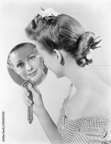 Reflection of a young woman, looking in a mirror 