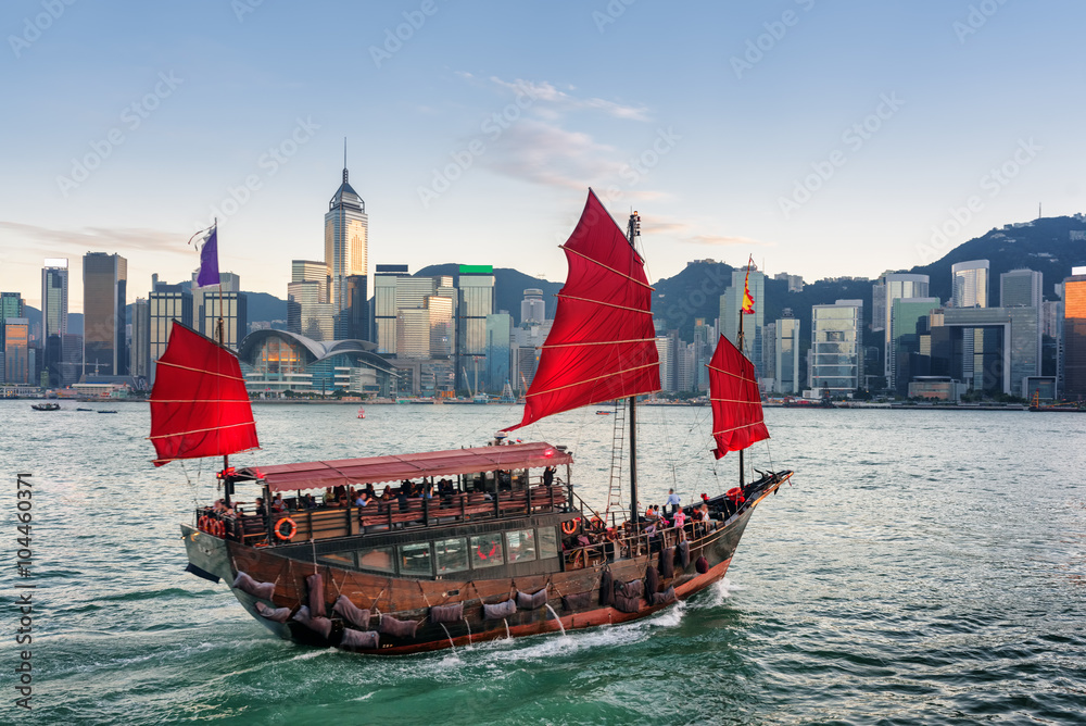 Fototapeta premium Tourists on sailing ship with red sails crosses Victoria harbor
