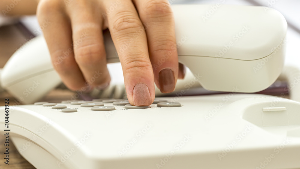 Closeup of female hand dialing telephone number Closeup of female hand dialing telephone number