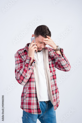 A young boy is upset talking on the phone