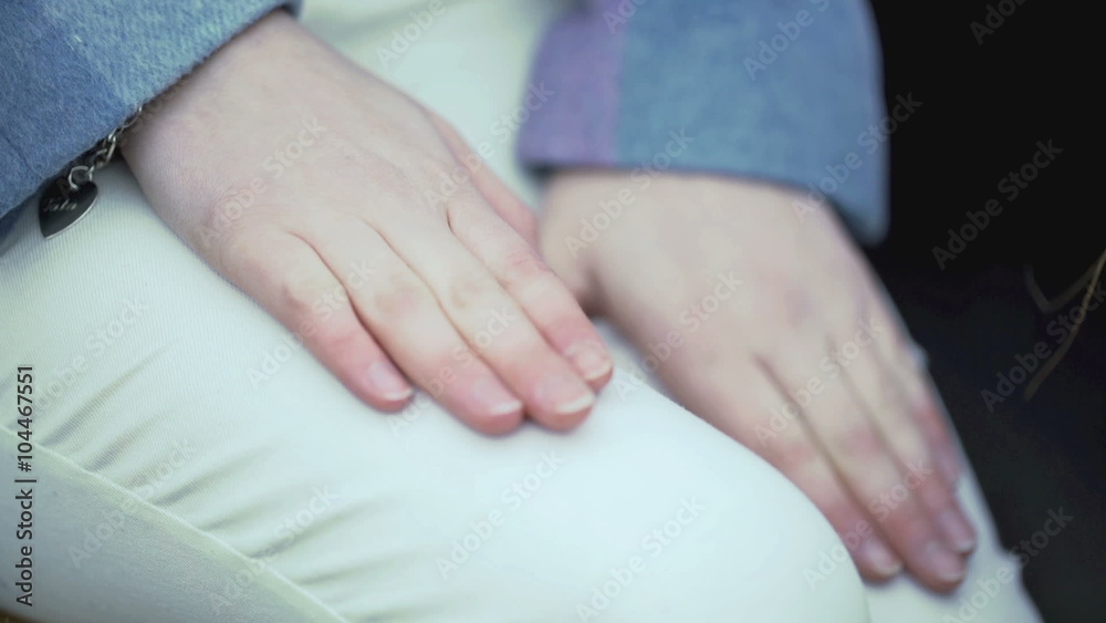 View of female hands clapping on her white trousers, steadycam shot
View of female hands clapping on her white trousers, steadycam shot