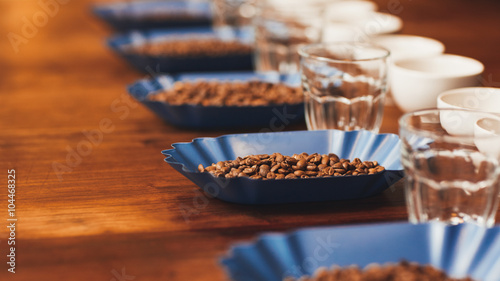 Row of containers with roasted coffee beans on table