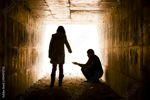 poor man and girl silhouette in tunnel photo