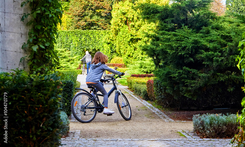 Father and daughter enjoy riding on bikes in park