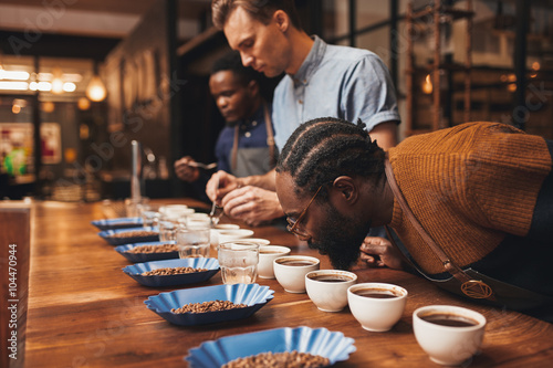 Baristas training with variety of coffee beans in modern roaster