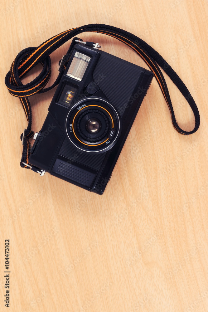 Old camera, vintage camera films popular in the past on wooden desk table.