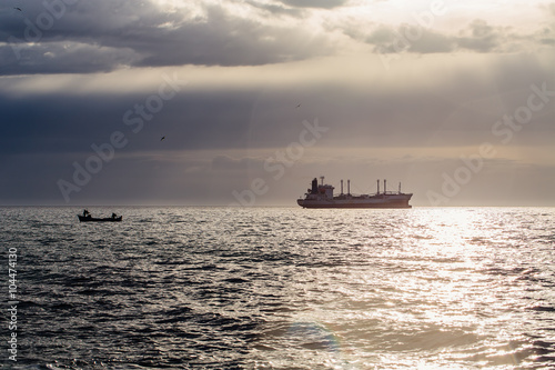 Cargo ship sailing on sunrise near the beach © ValentinValkov