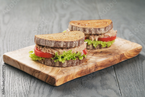 Obraz na płótnie rye bread sandwich with tuna and vegetables on wood background
