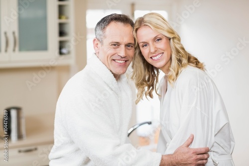 Cute couple cuddling in bathrobes