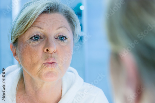 ältere frau schaut auf ihr spiegelbild © Racle Fotodesign