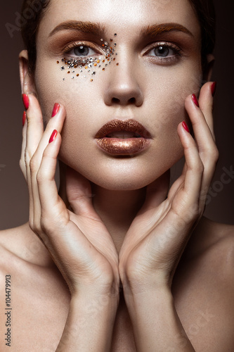 Beautiful girl with a gentle make-up and crystals on the face. 