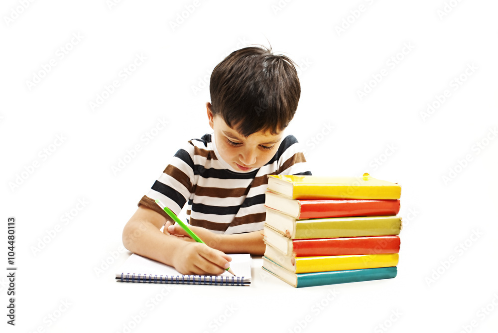 School boy sitting and writing in notebook. Isolated on white background School boy sitting and writing in notebook. Isolated on white background
