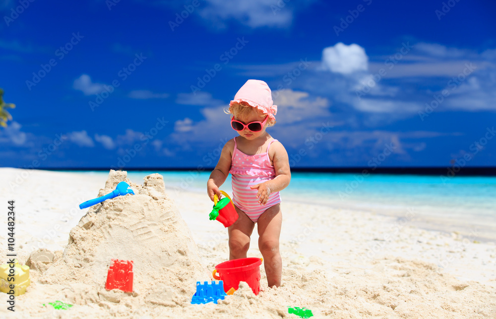cute little girl building sandcastle on beach cute little girl building sandcastle on beach