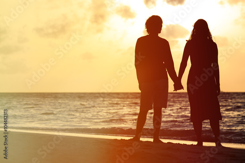 romantic couple holding hands at sunset