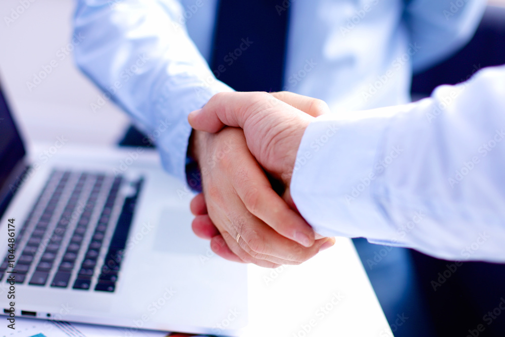 Business meeting at the table shaking hands conclusion of the contract Business meeting at the table shaking hands conclusion of the contract