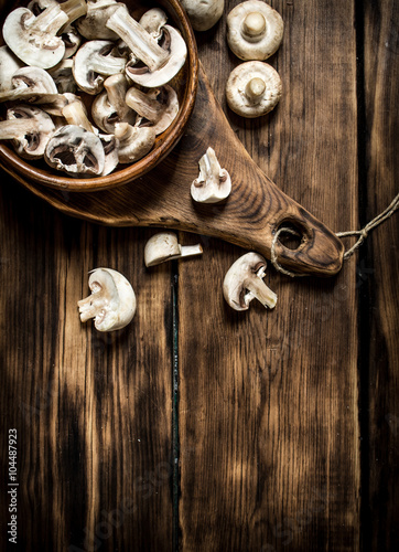Sliced mushrooms in a wooden Cup on the old Board.