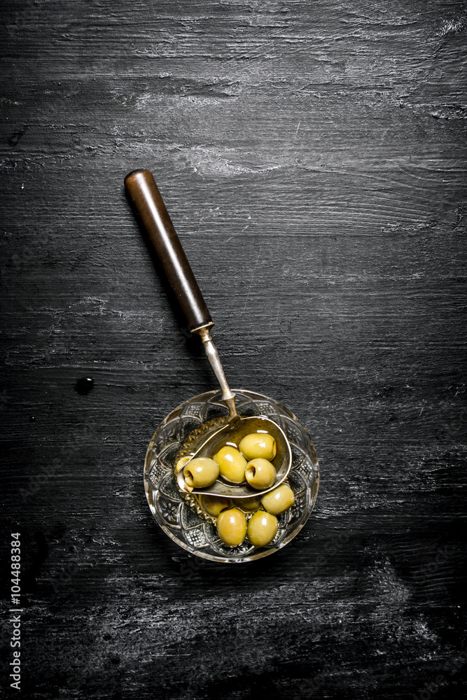 Olives in olive oil with an old spoon. Olives in olive oil with an old spoon.