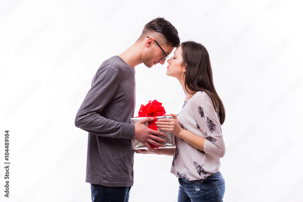 Young hipster Man Giving a Gift on holiday his girlfriend. She want kiss him. Caucasian couple against white background. Young hipster Man Giving a Gift on holiday his girlfriend. She want kiss him. Caucasian couple against white background.