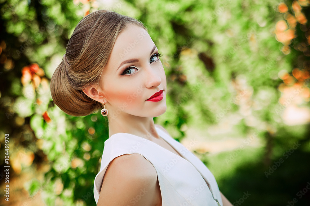 Naklejka premium Beautiful romantic woman in light dress posing in a blooming gar