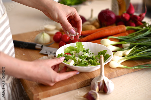 Cook's hands preparing vegetable salad - closeup shot