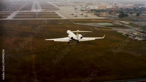 Aerial of a private jet landing at an airport, from behind. photo