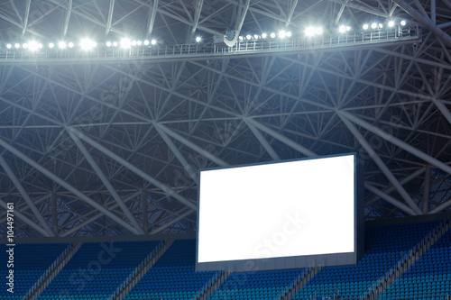 Blue seats and electronic billboard display at stadium