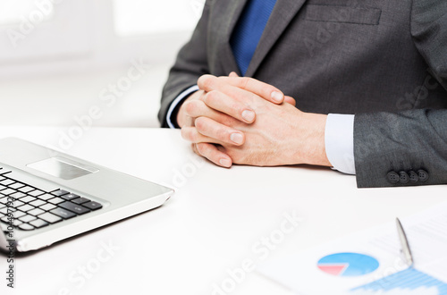 close up of businessman with laptop and papers photo