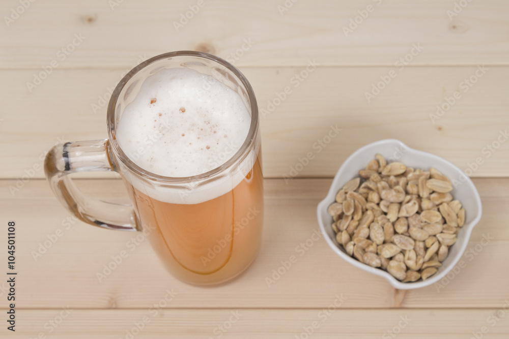 Mug of beer and peanuts in the bowl. Studio shoot Mug of beer and peanuts in the bowl. Studio shoot