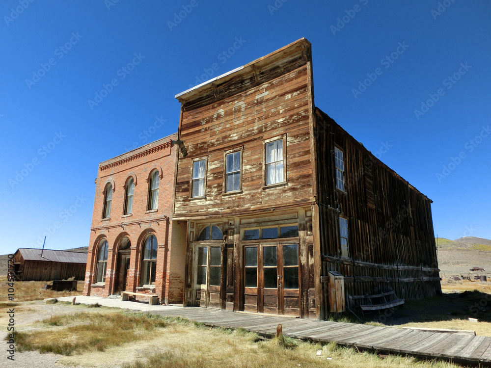 Old vintage abandoned weathered buildings in Bodie, California - landscape color photo
