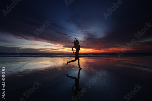 Woman running on the beach at sunset © yellowj