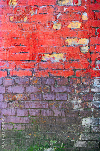 Grungy brick wall painted in pink and violet colors