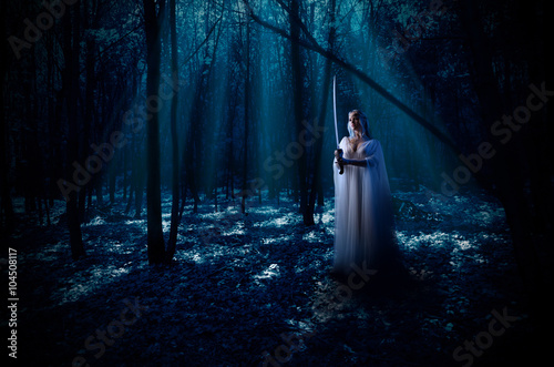 Elven girl with sword at night forest