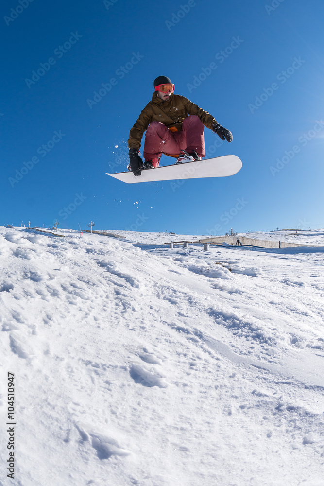 Snowboarder jumping against blue sky Snowboarder jumping against blue sky