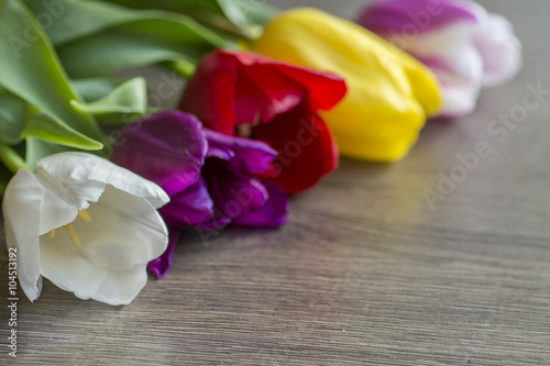 Bouquet of five delicate colored tulips on the table