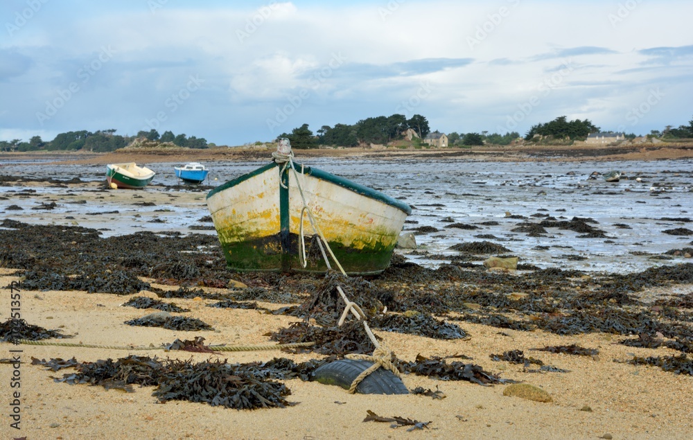 Barque sur le sable à marée basse à Port-Blanc en Bretagne Barque sur le sable à marée basse à Port-Blanc en Bretagne