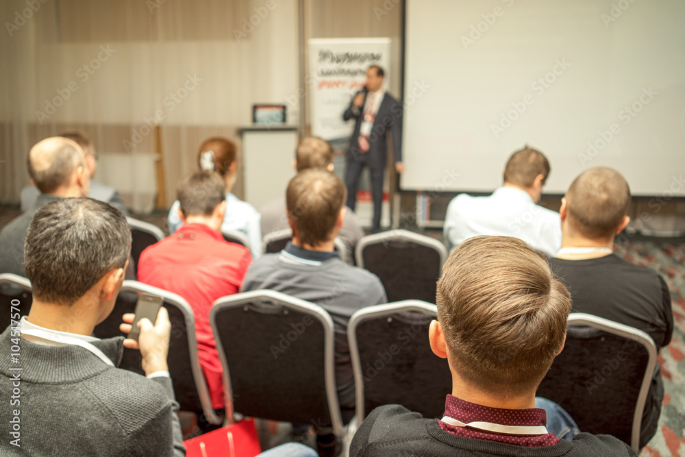 Speaker Giving a Talk at Business Meeting. Audience in the conference hall. Business and Entrepreneurship. Copy space on white board. Speaker Giving a Talk at Business Meeting. Audience in the conference hall. Business and Entrepreneurship. Copy space on white board.
