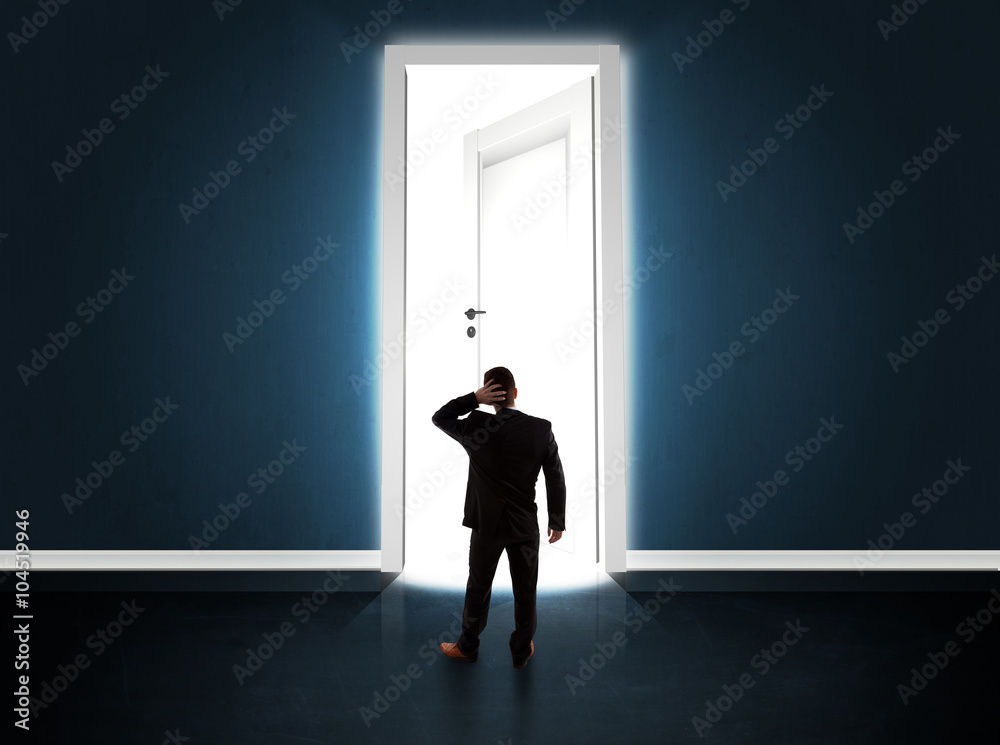 Fototapeta premium Business man looking at big bright opened door