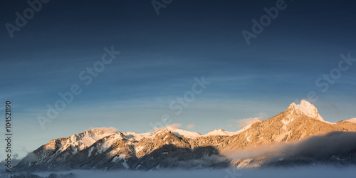 panorama of mountain chain hahnenkamm in winter at sunrise
