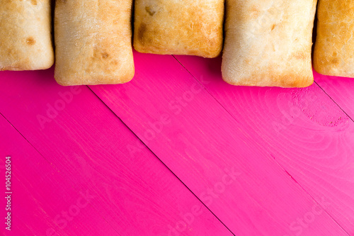Border of Italian ciabatta bread on exotic pink