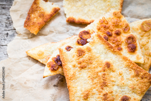 Crunchy pizza dough tiangles on rustic background photo